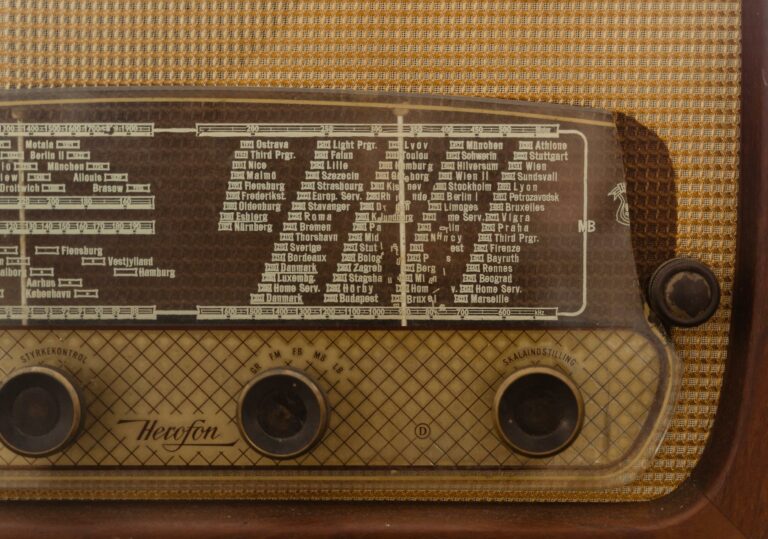 Close-up of a vintage radio displaying station names and frequency dial for a nostalgic effect.