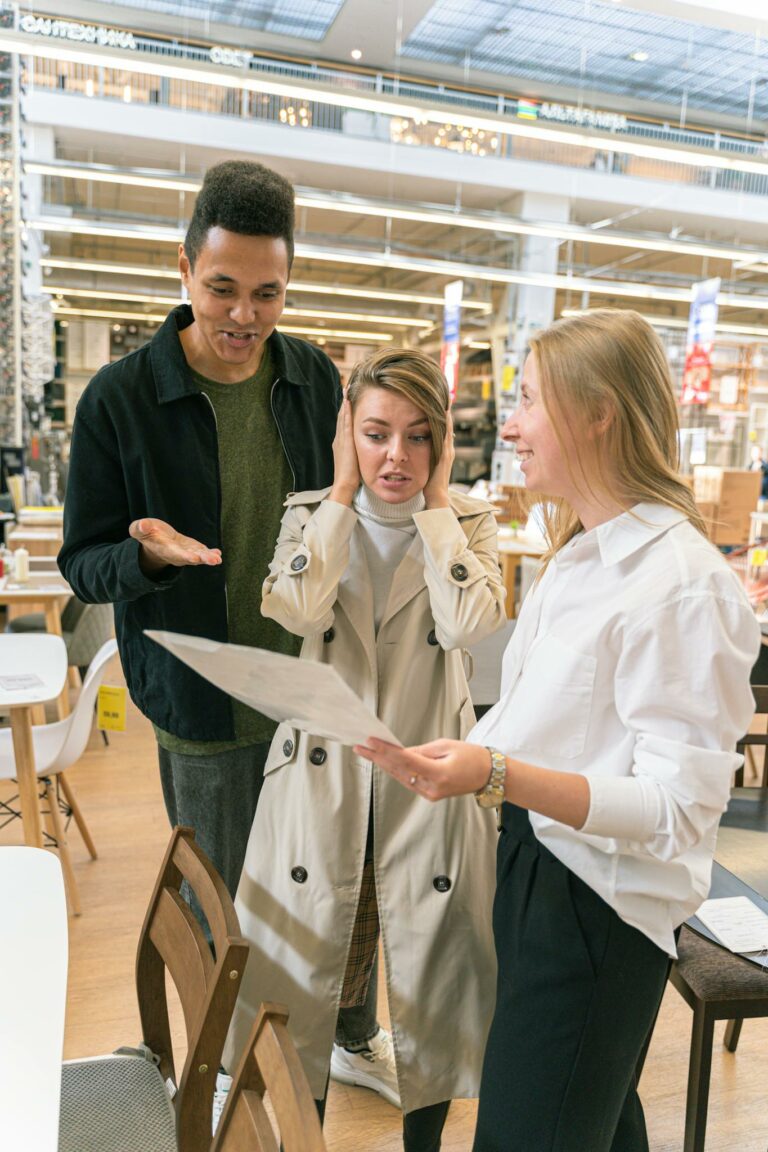 Three colleagues discussing retail strategies in a bright, modern store setting.